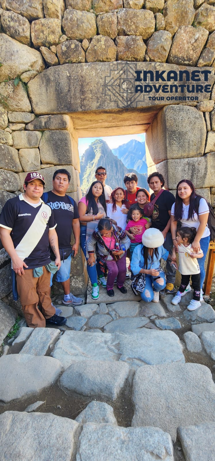 InkaNet Adventure tour group at MachuPicchu with llamas in the foreground.